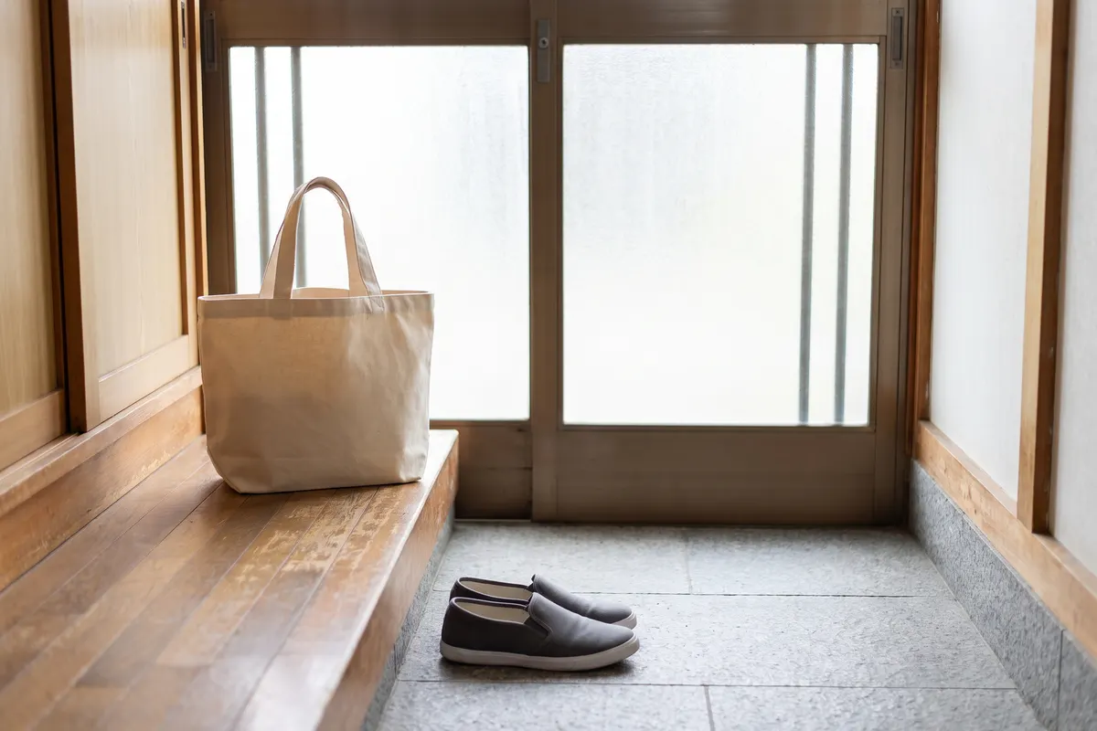 お宅の玄関の上がり口に置いた布の袋と、そろえて脱いだ靴