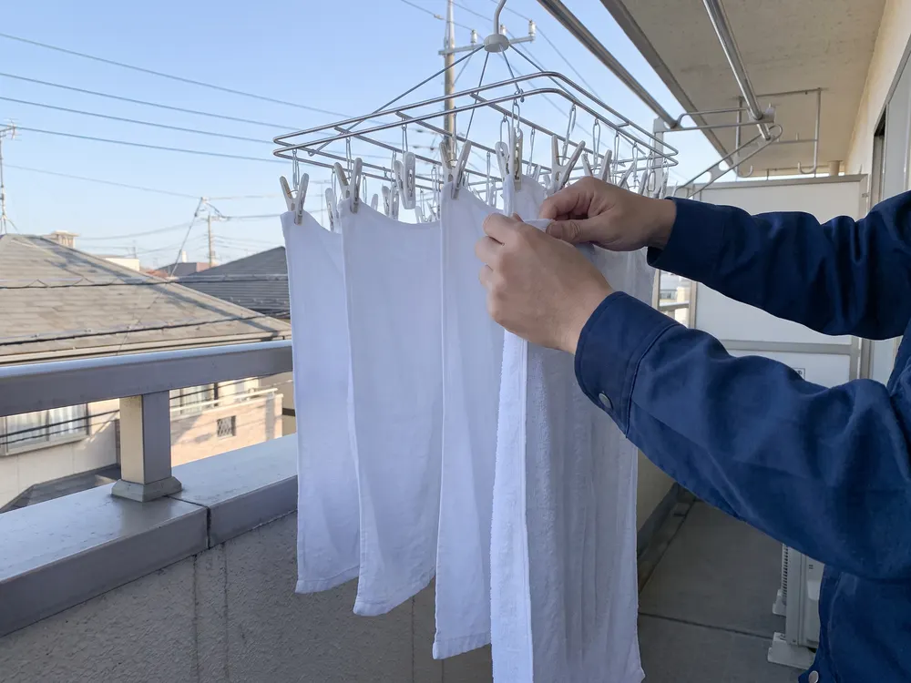ベランダでタオルを干す手元