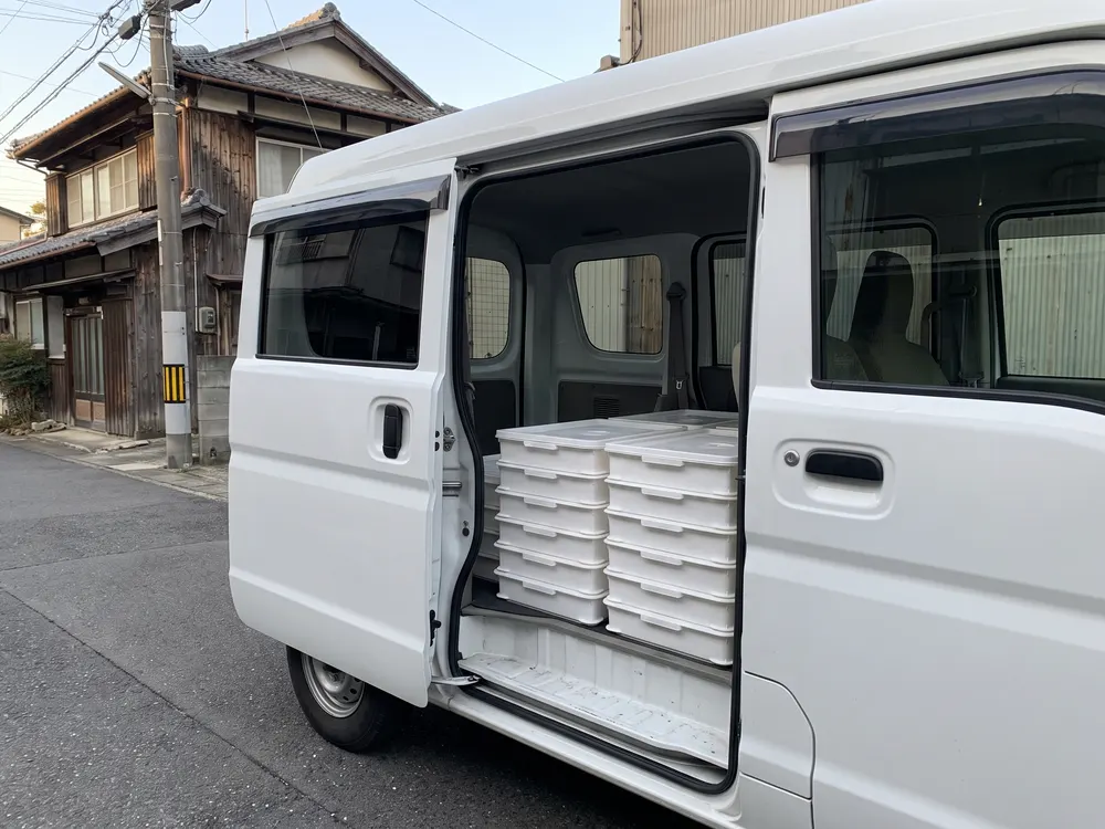 車の荷台に積んだ、ふたの付いた白い箱